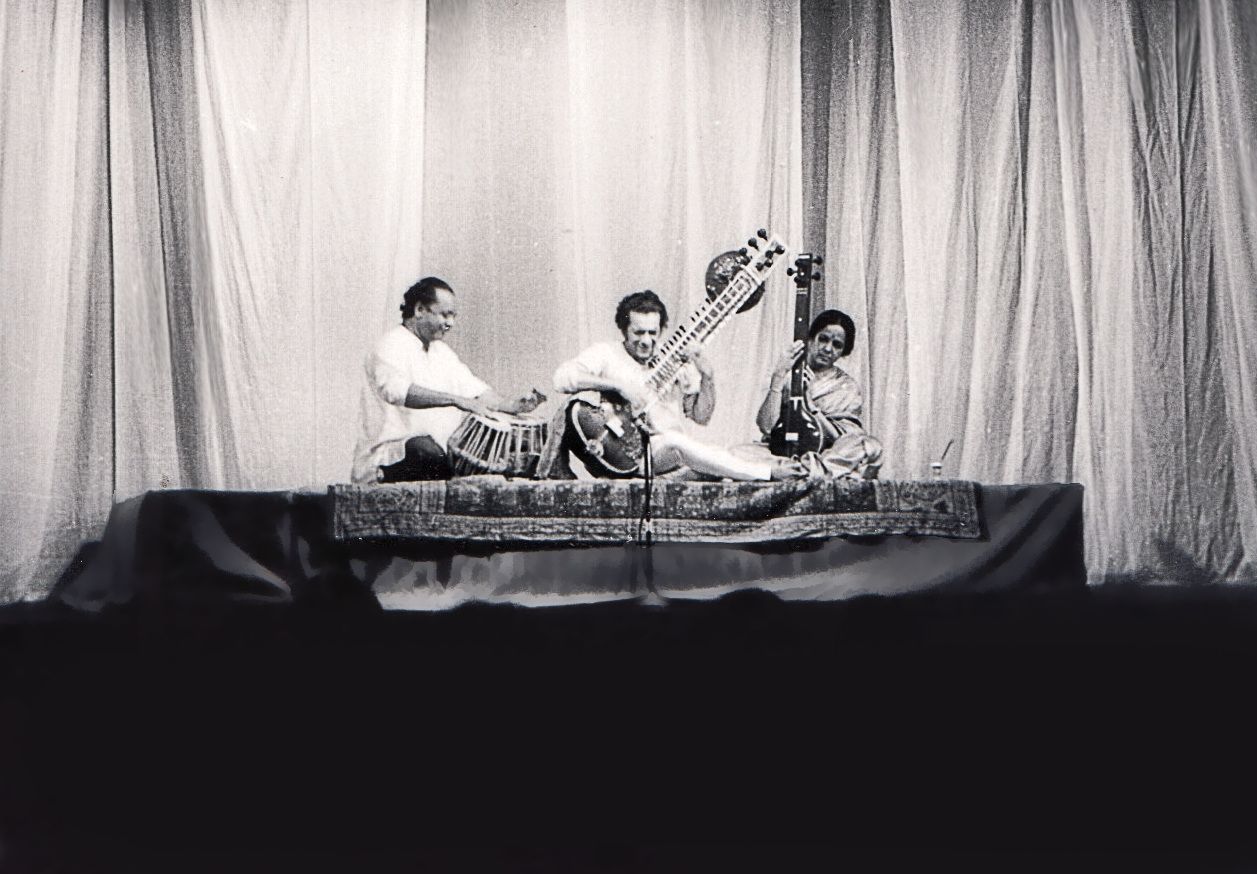 A black and white image of Ravi Shankar taken in 1967 at the LCR. He is flanked by two traditional Indian musicians and he is playing the sitar.