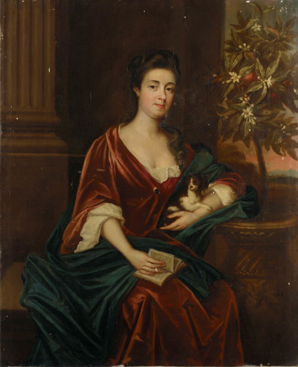 A woman in an orange velvet dress cradles a puppy
