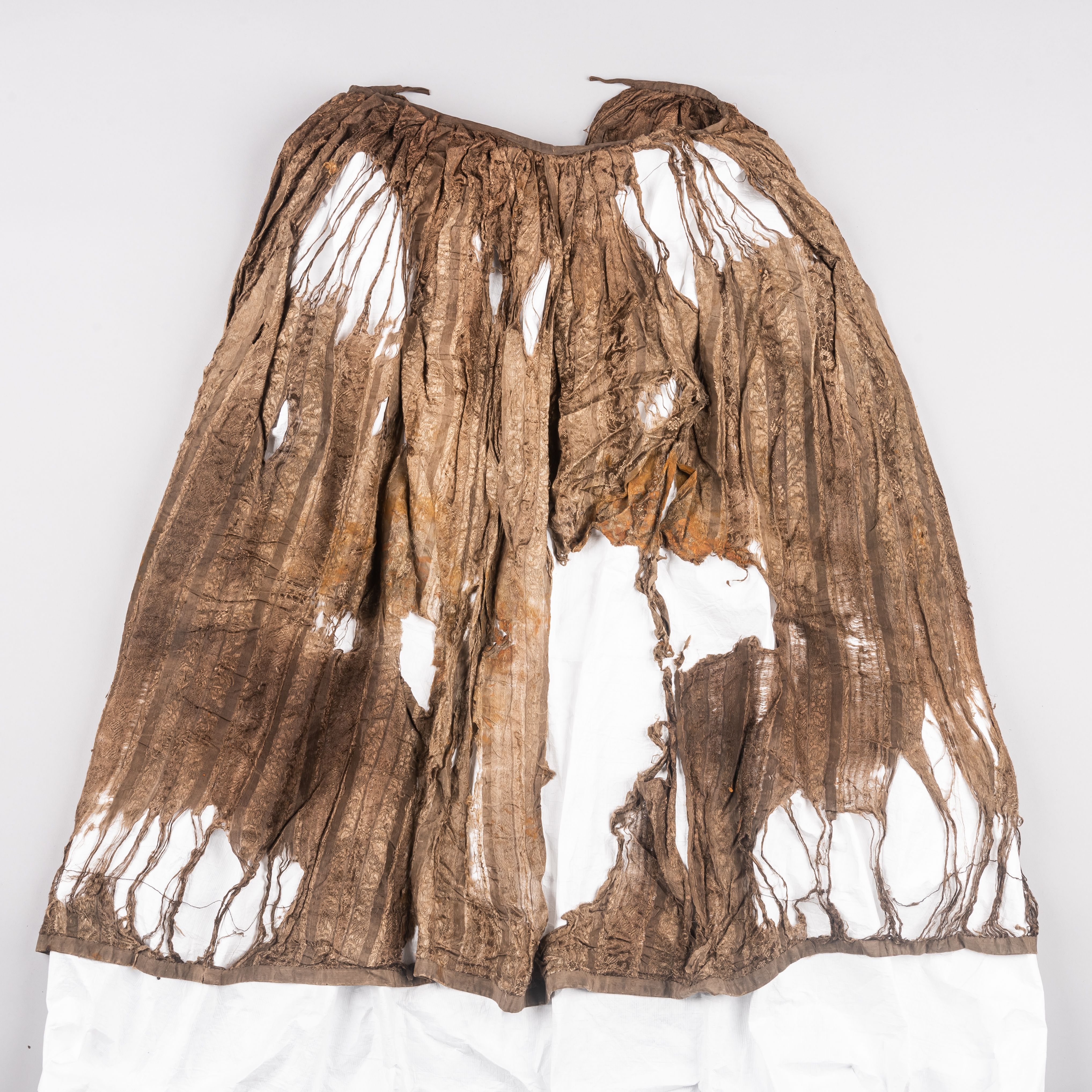 A very old skirt with a visible pattern on it and several holes