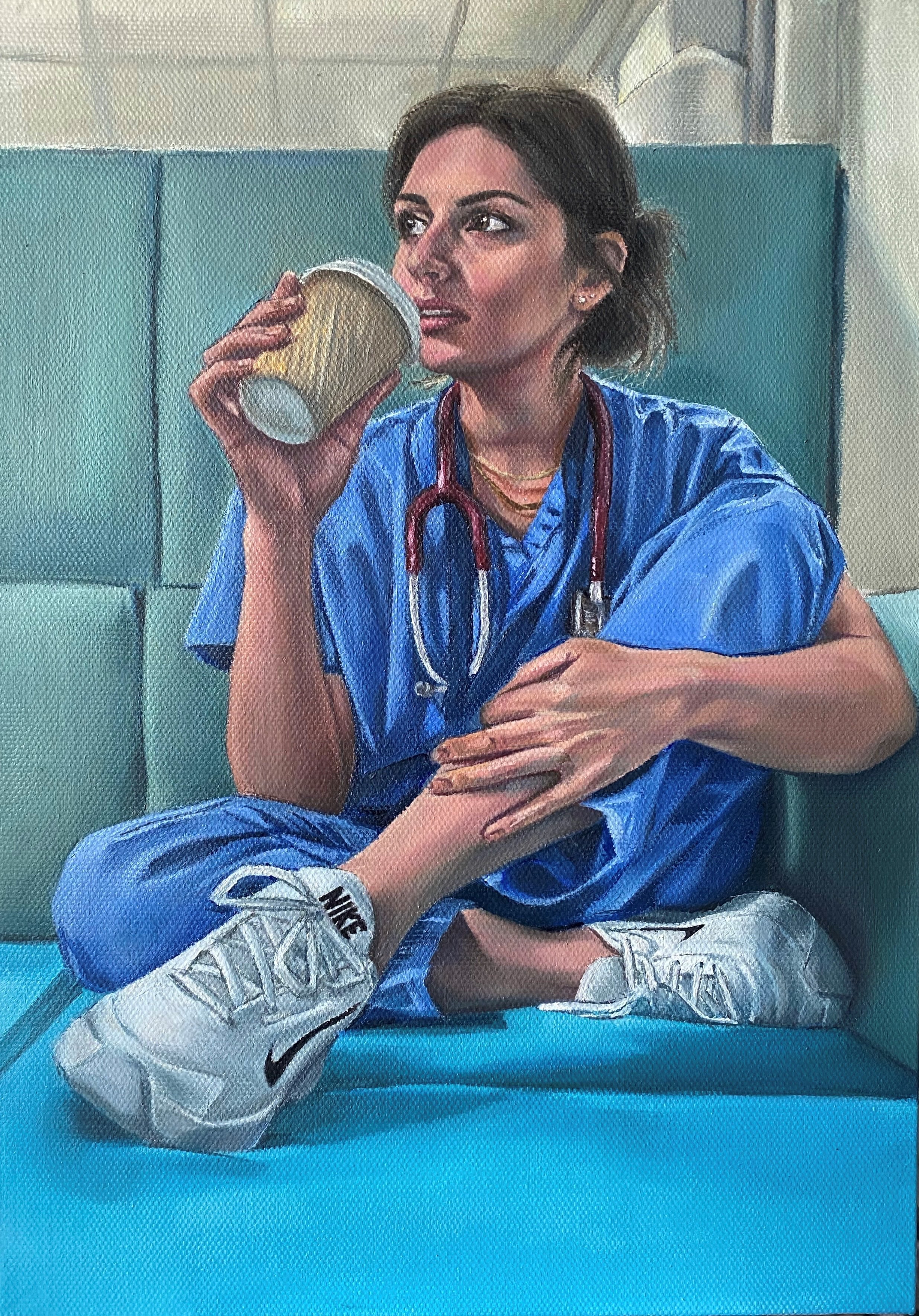 An oil painting of a doctor in blue scrubs with a stethoscope round her neck drinks a coffee during a break at work