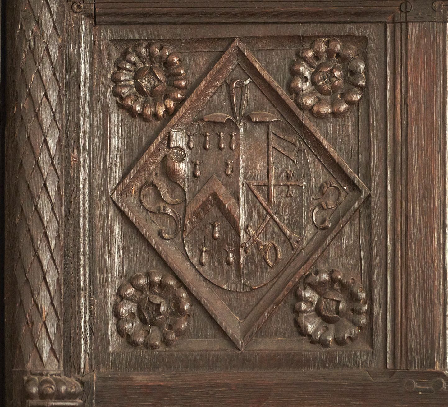 A merchants' mark carved into a wooden wall panel.