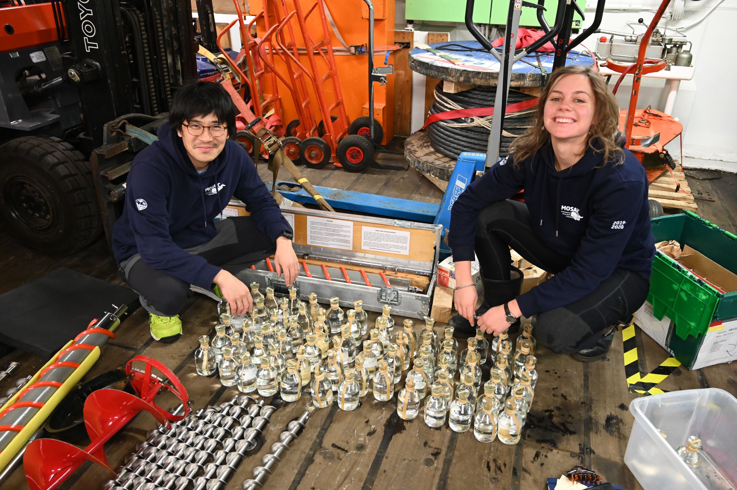 Two scientists conducting analysing bottles of seawater