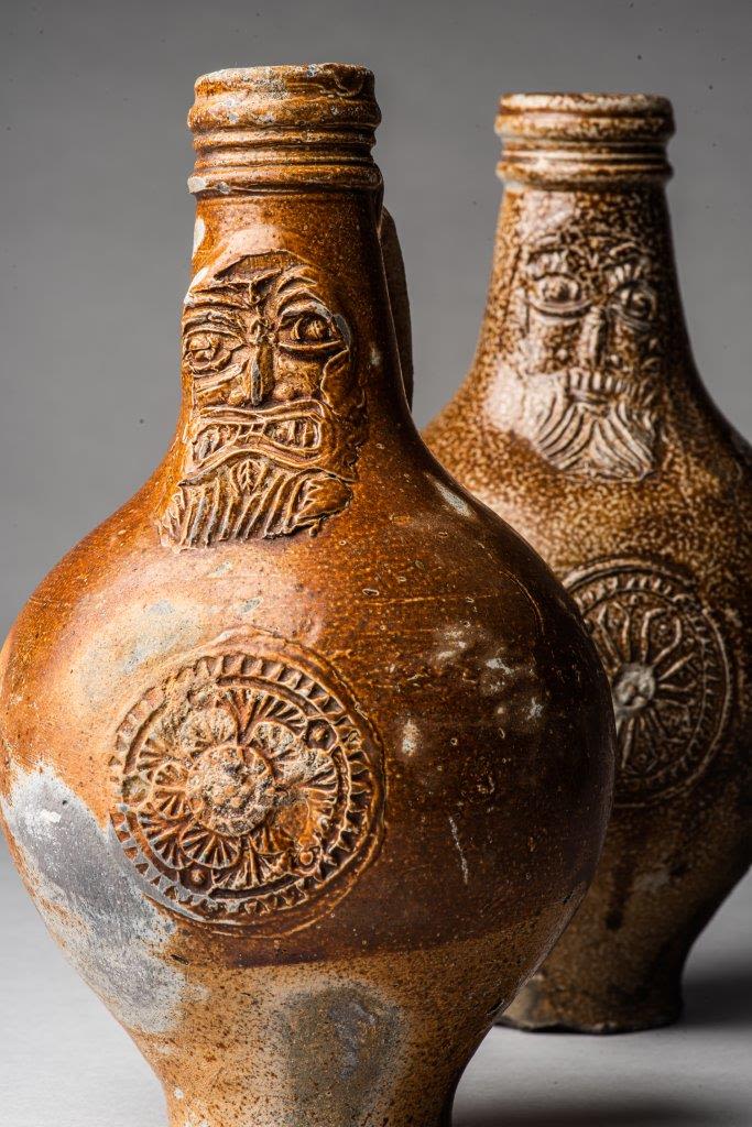 Bellarmine bottles with faces and symbols inscribed