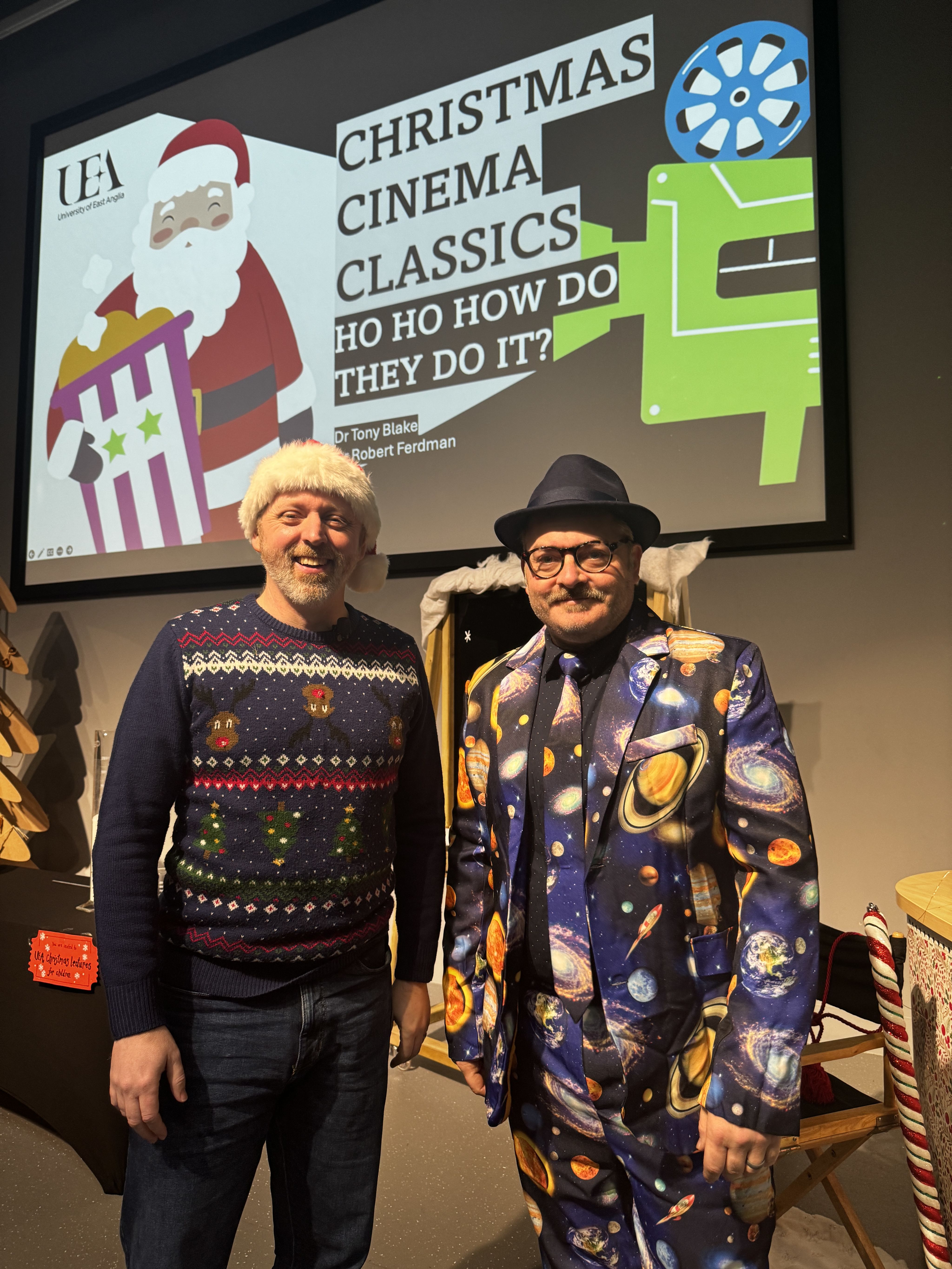 Dr Tony Blake (left) in Christmas jumper and Santa hat, and Dr Rob Ferdman (right) in all in one suit with planets on