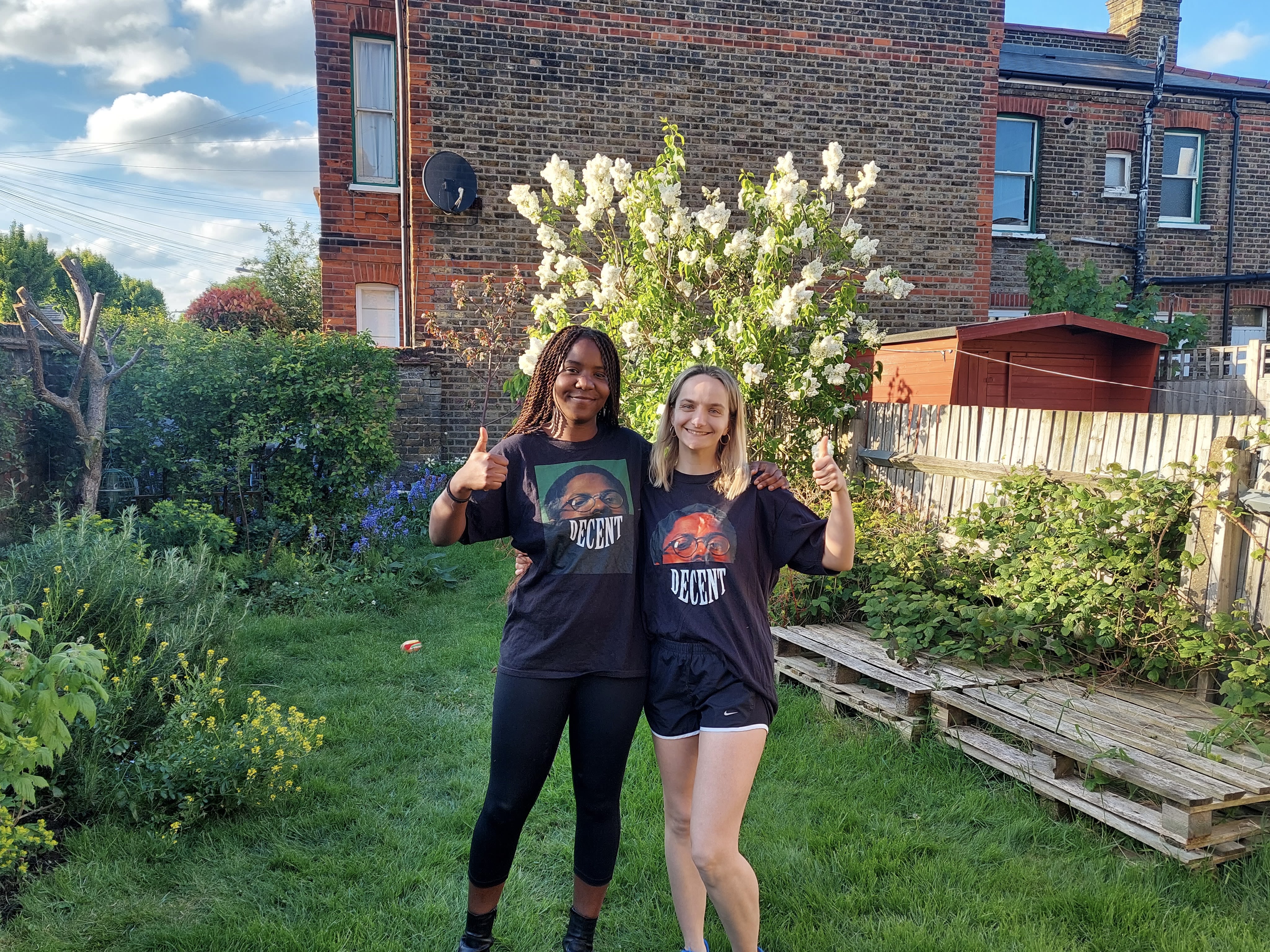 Naomi Rhodes and Jodie Snow standing with thumbs up in a back garden