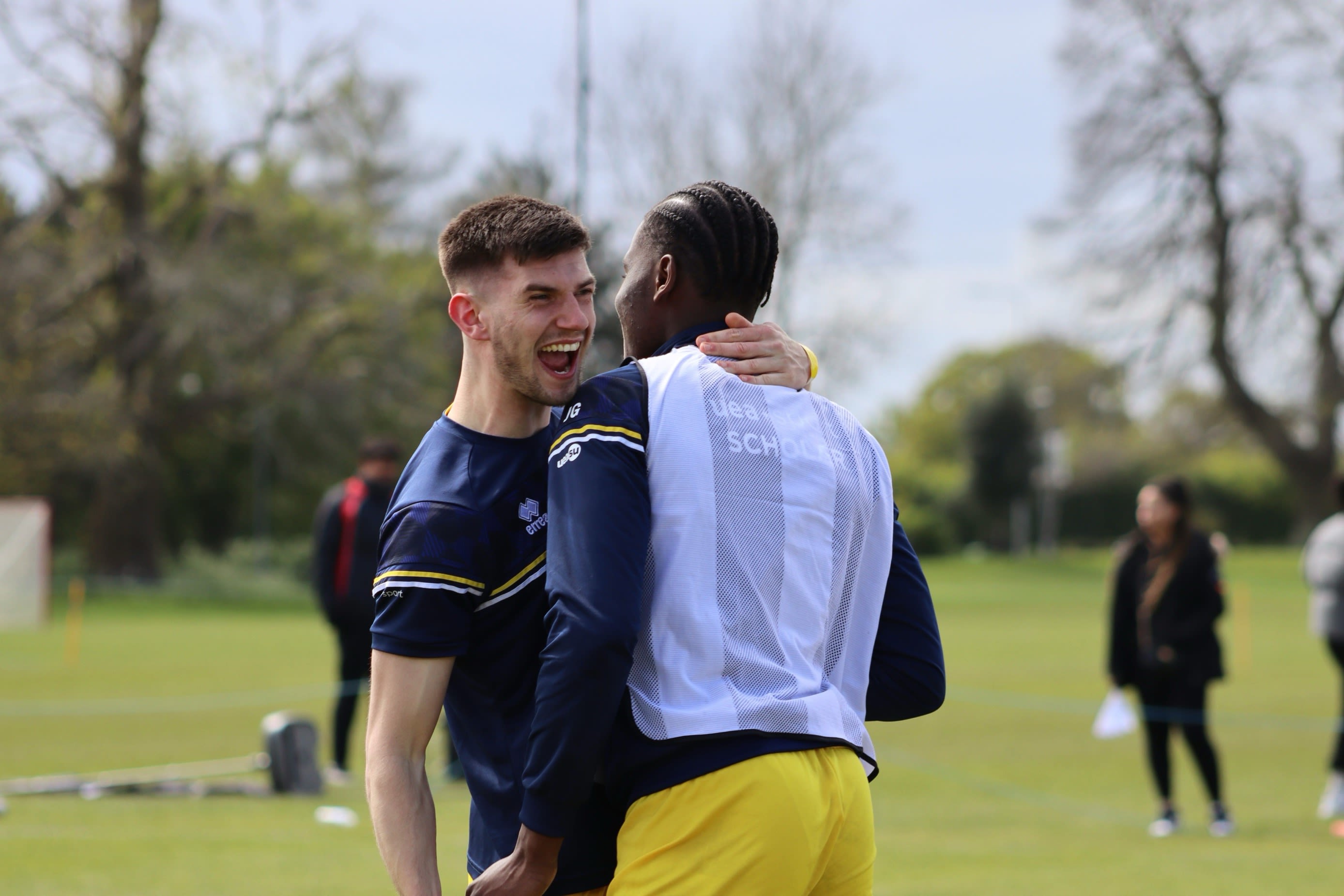 Two people embracing as they cheer together after a goal