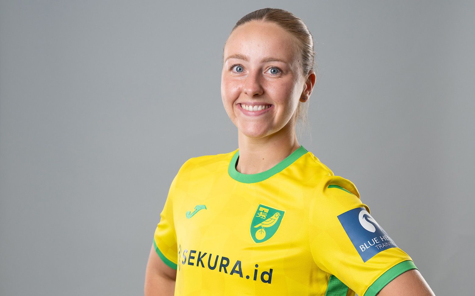 Millie Daviss in her yellow and green Norwich City kit