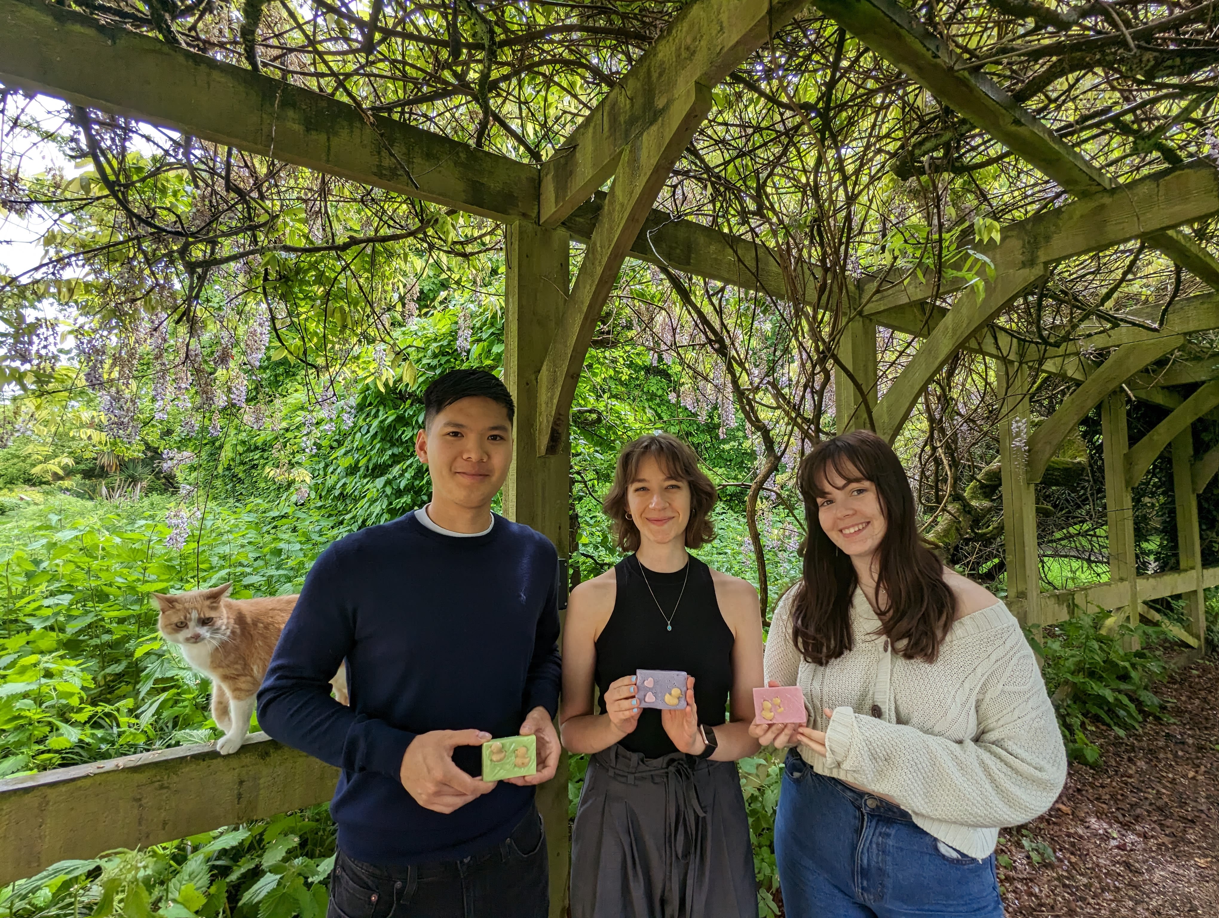 L-R: Conrad Yip, Natalie Chabot and Katherine O'Connor with some of the handmade soaps (and a surprise visit from Sylvester the campus cat!)