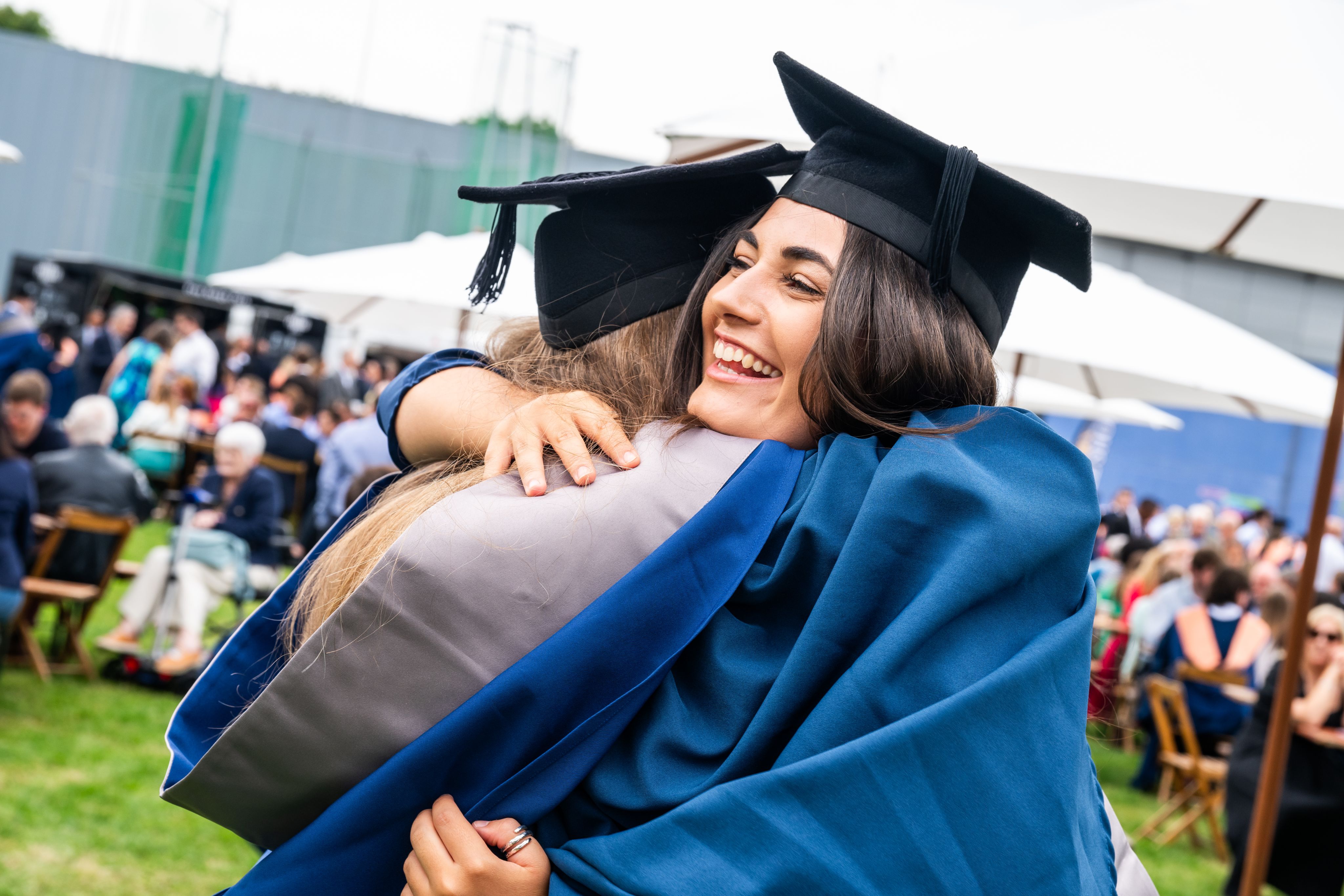 Two graduates in blue robes and graduation cap