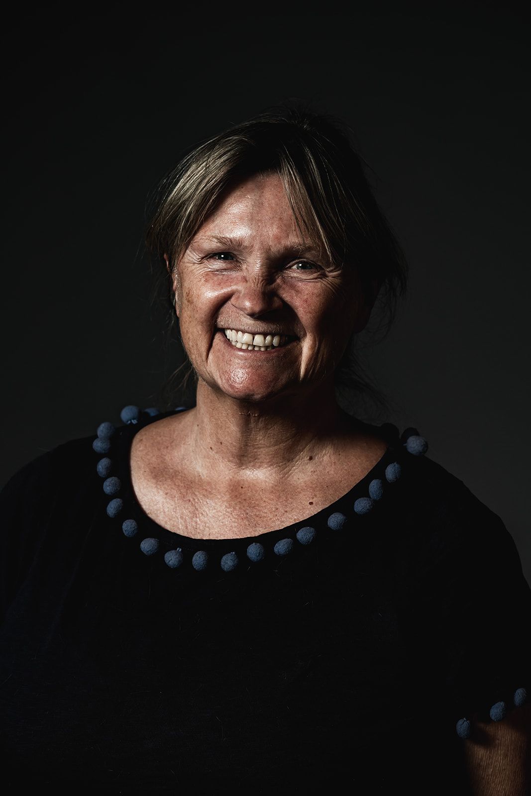 Heasd and shoulders of Prof Joanne Clarke, woman in her 50s, smiling and wearing back dress with blue spots around the neckline.